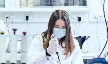 Scientists working in a lab, pointing at a whiteboard